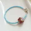 Flower bouquet glass charm and blue cat's eye bead bracelet with silver heart toggle bracelet