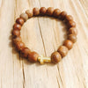 Golden cross charm is the center of attention among sandalwood beads.